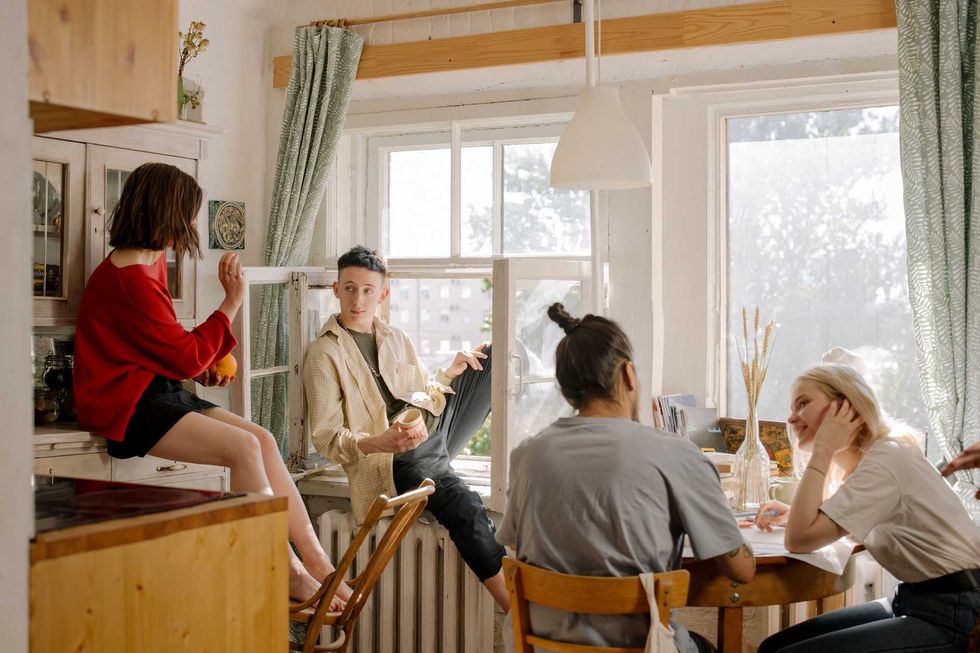 Four friends spending time together in a brightly lit kitchen.