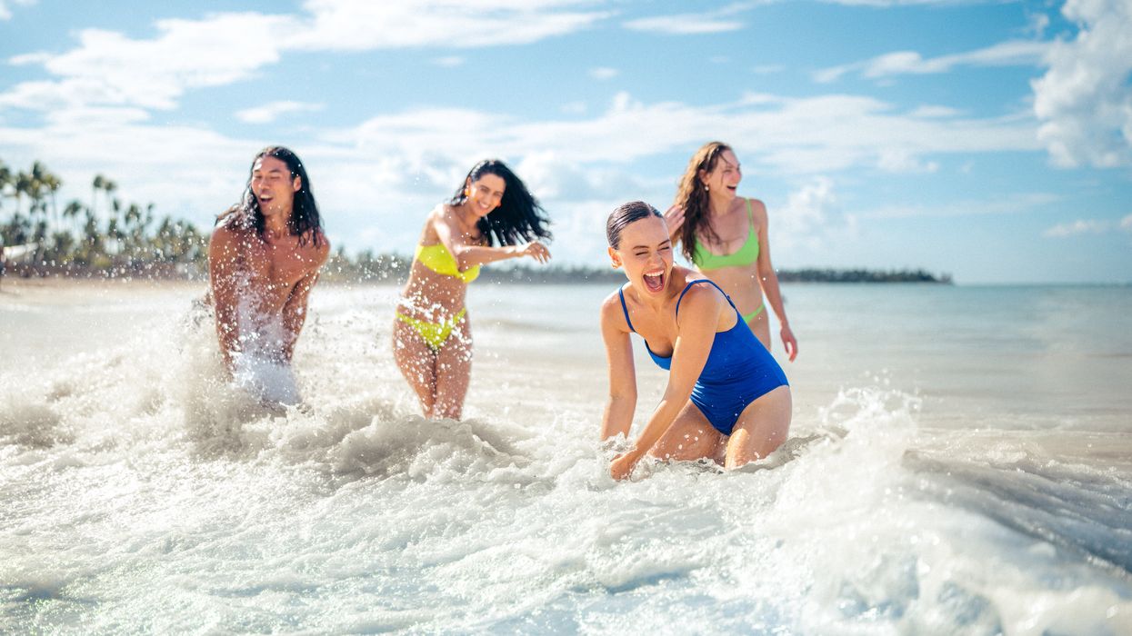 Four people having fun in the ocean.