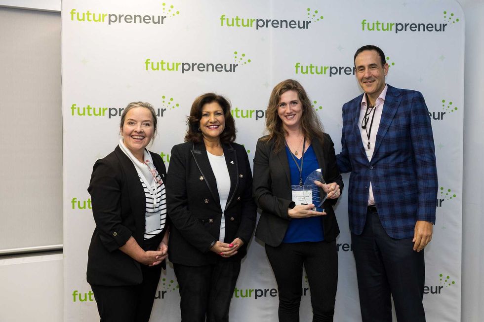 Four people in businesswear in front of a sign that says Futurpreneur.