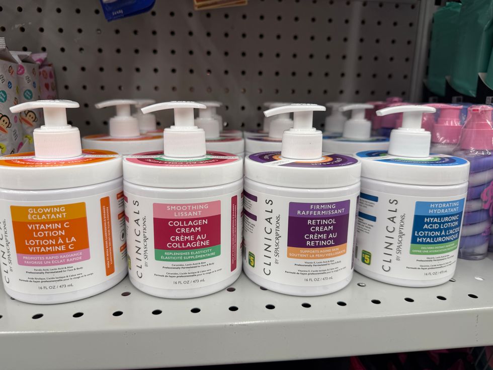 Four white tubs of lotion with colourful labels on a store shelf.