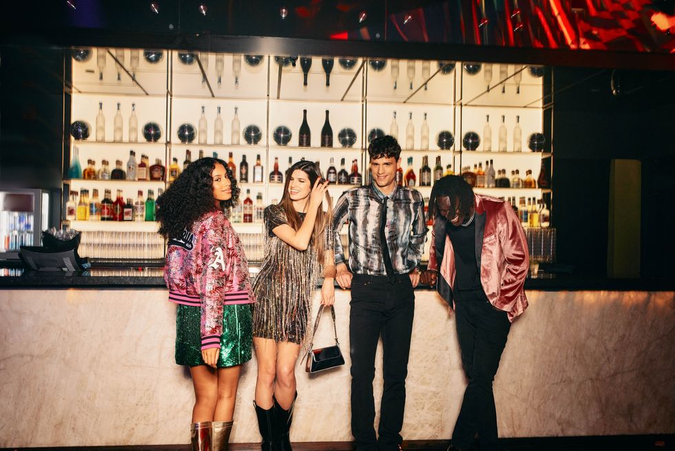 Four young people standing at the bar of a Club Al\u00e9a.
