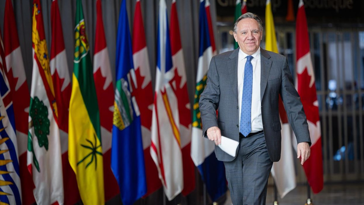 François Legault devant différents drapeaux des provinces canadiennes.