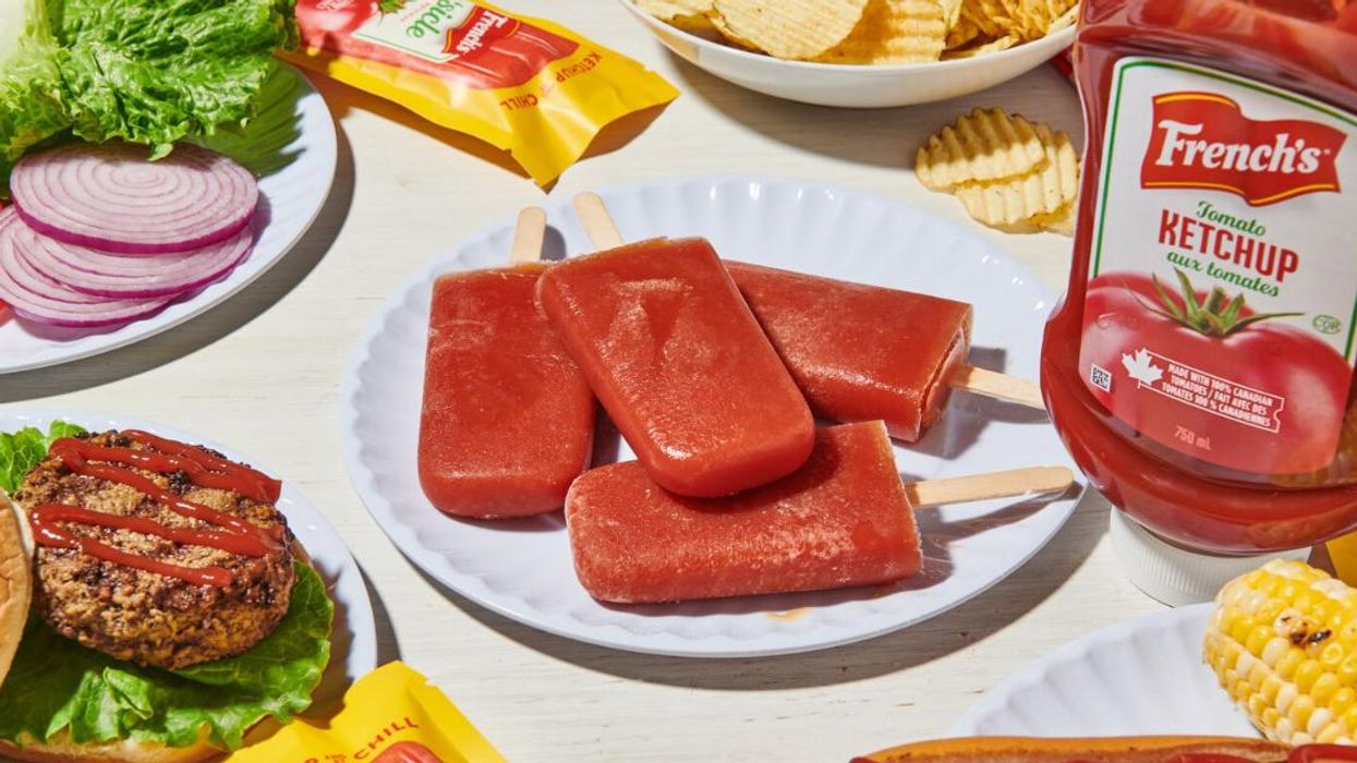 "Frenchsicles" on a table with ketchup and a burger.