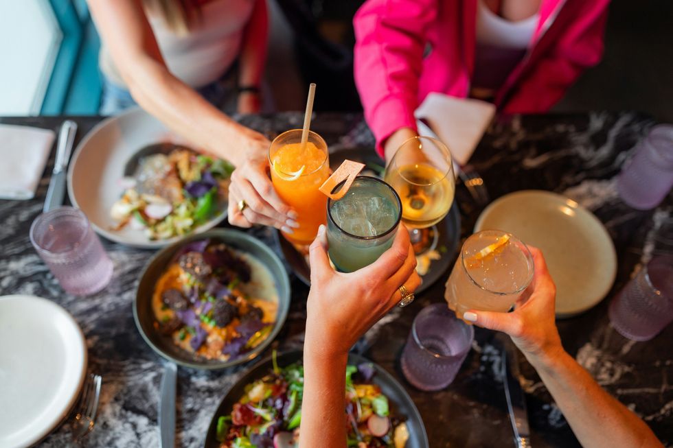 Friends enjoying cocktails and dinner together at a restaurant.