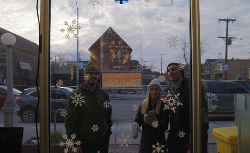 Friends hunting for snowflakes in a store window.