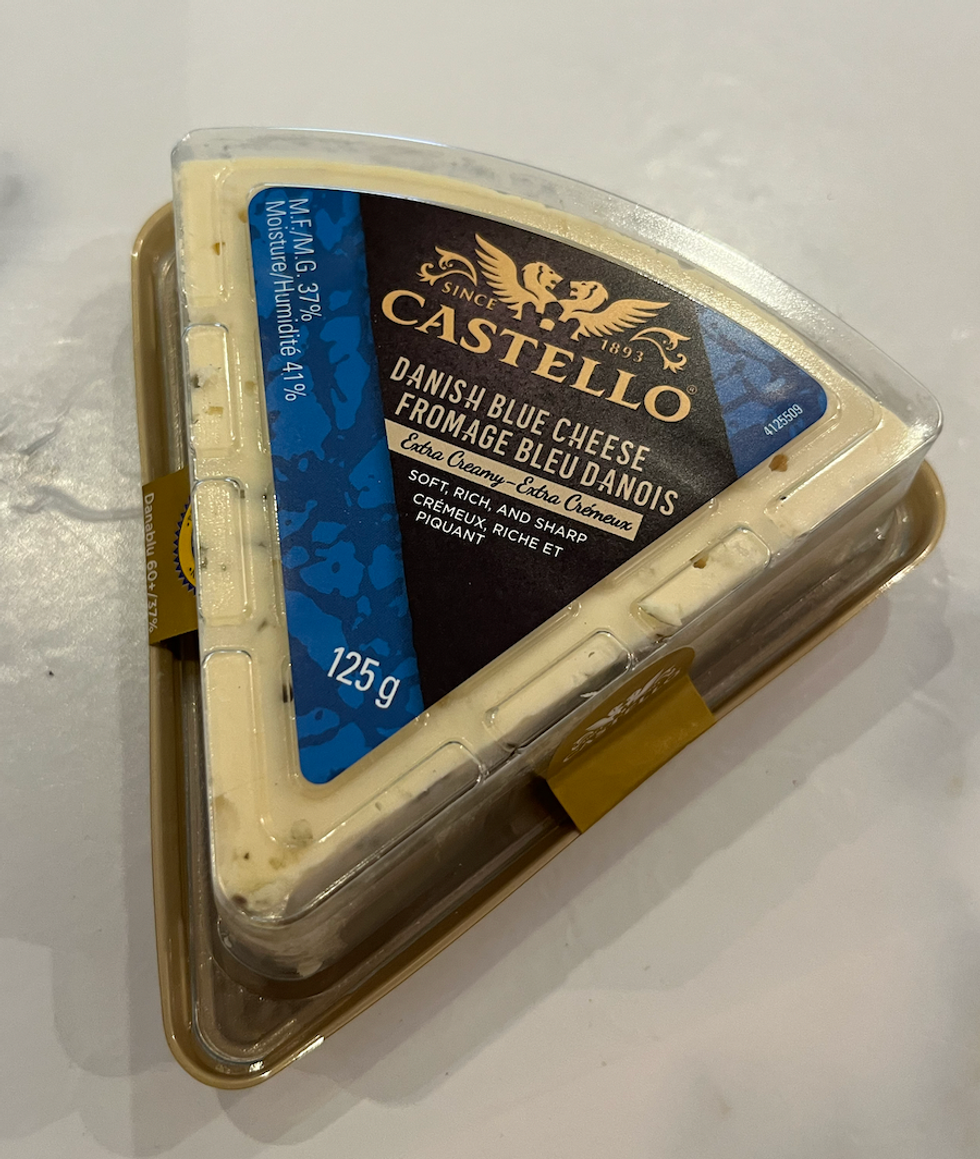 Fromage bleu danois Castello extra cr\u00e9meux pos\u00e9 sur un comptoir en marbre.