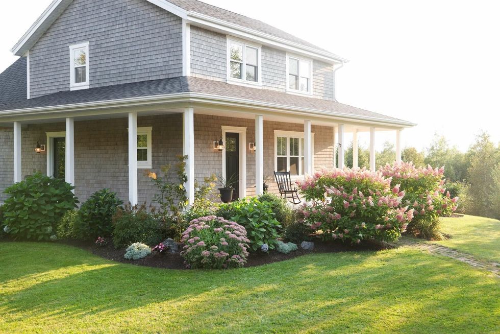 Front yard of the PEI home filled with flowering plants.