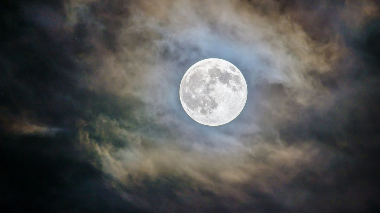 full moon in the night sky surrounded by clouds