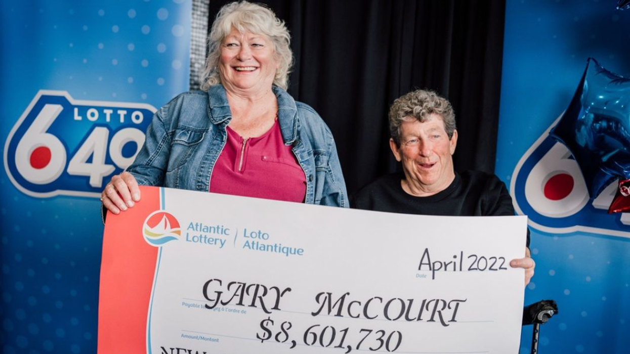 Gary and Joy holding a cheque for $8.6 million.