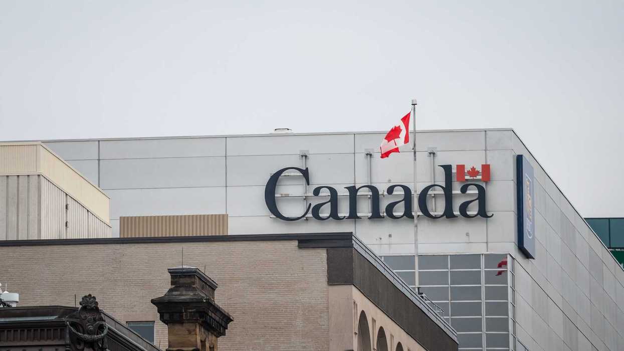 government of canada sign and canadian flag on building