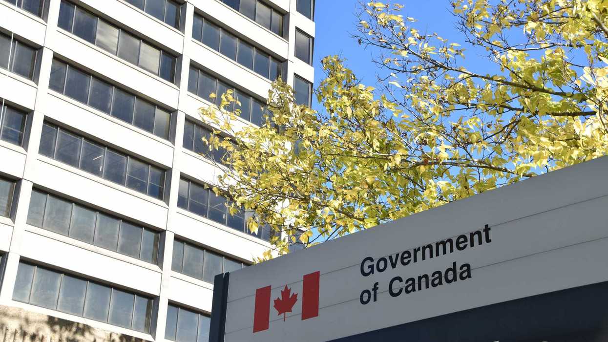 government of canada sign with canadian flag logo beside building