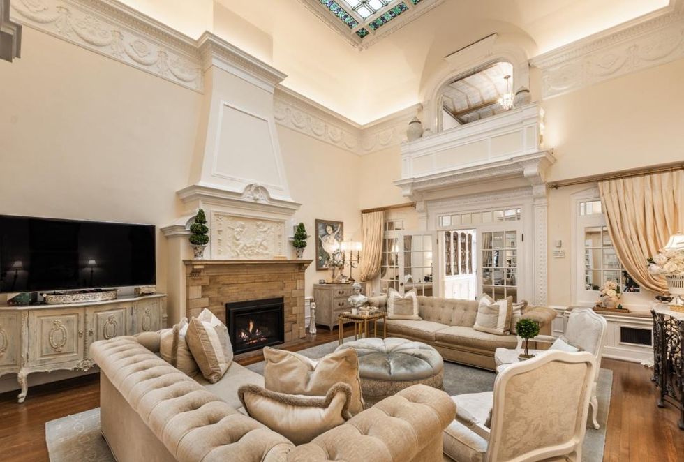 Grand salon avec plafonds de 18 pieds et foyer.