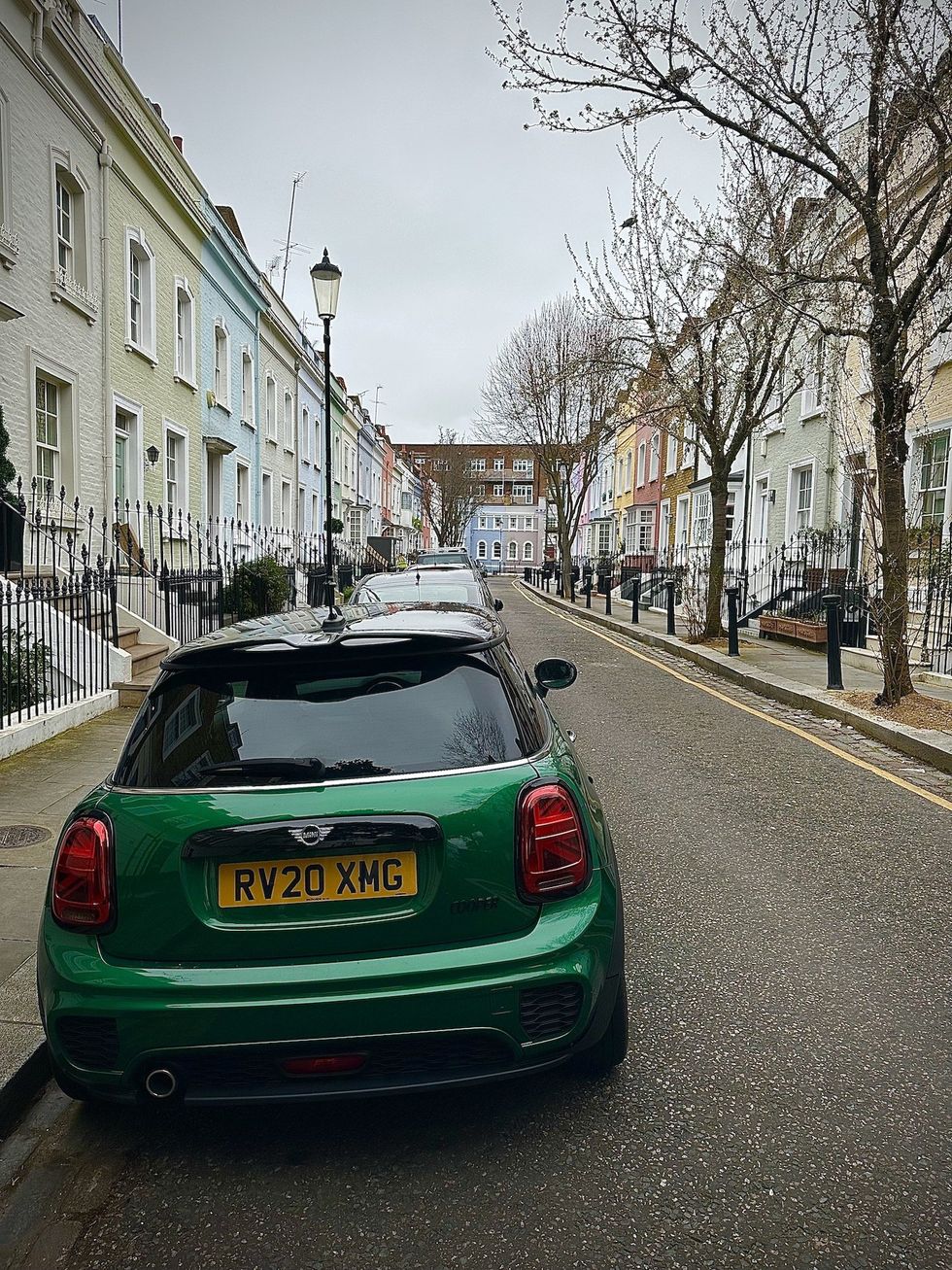 green mini cooper car on street in chelsea london with colourful houses