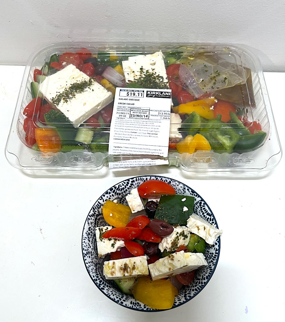 Gros plat rectangulaire en plastique de format familial rempli de \u200bsalade grecque, avec un petit bol de salade grecque.