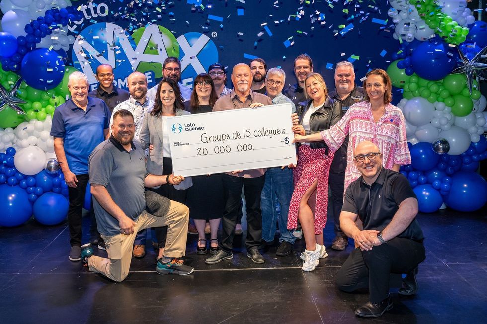 group of coworkers who won lotto max holding a $20 million cheque