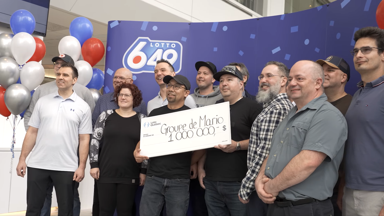 group of lotto 6/49 winners with a $1 million cheque