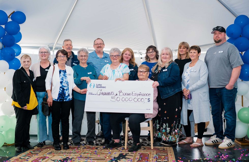 group of lotto max winners with a $50 million cheque