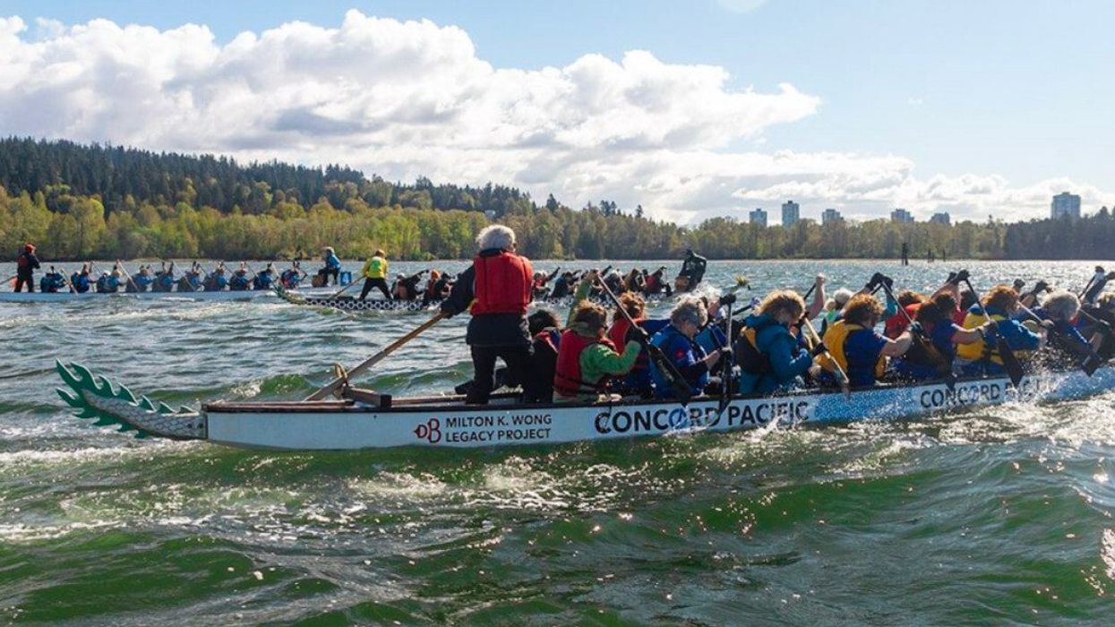 Groups of people on three dragon boats in the water taking part in a race.