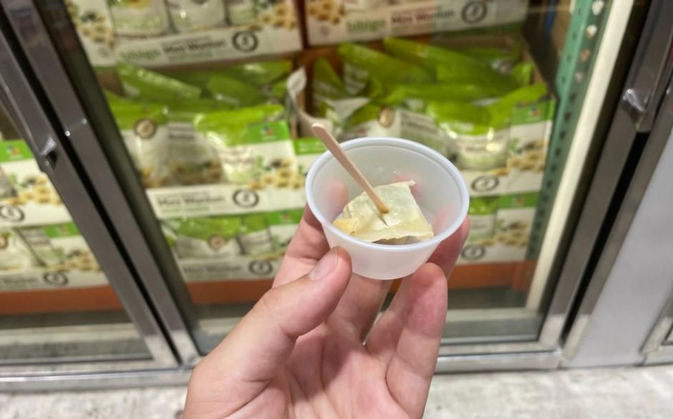 Half of a chicken wonton with a skewer in it.