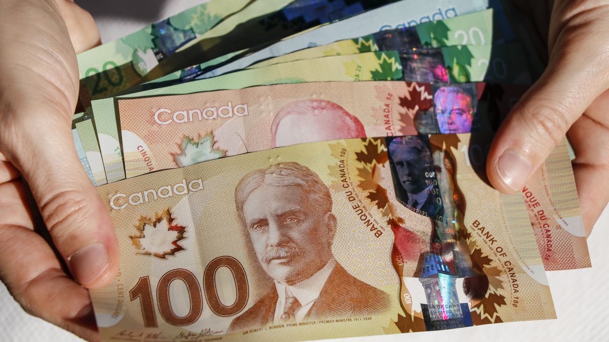 Hands holding Canadian cash.