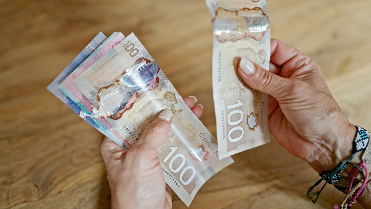 Hands holding Canadian money.