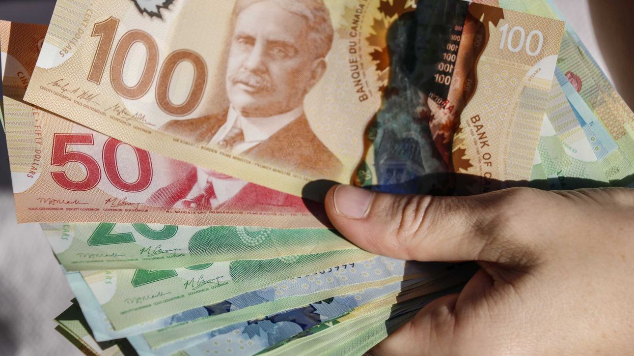 Hands holding Canadian money.