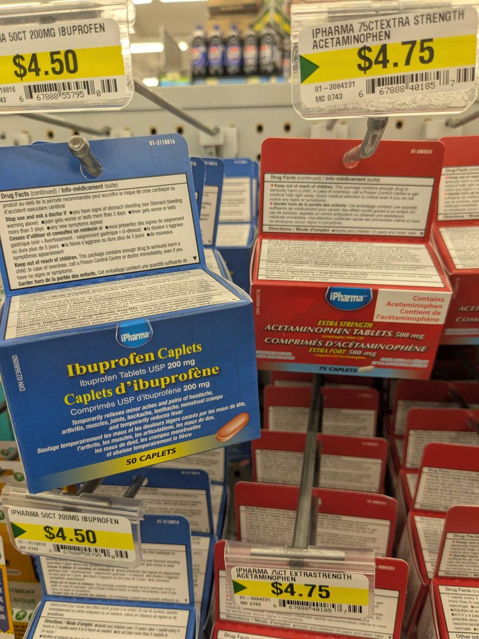 Ibuprofen and acetaminophen containers hanging on a shelf