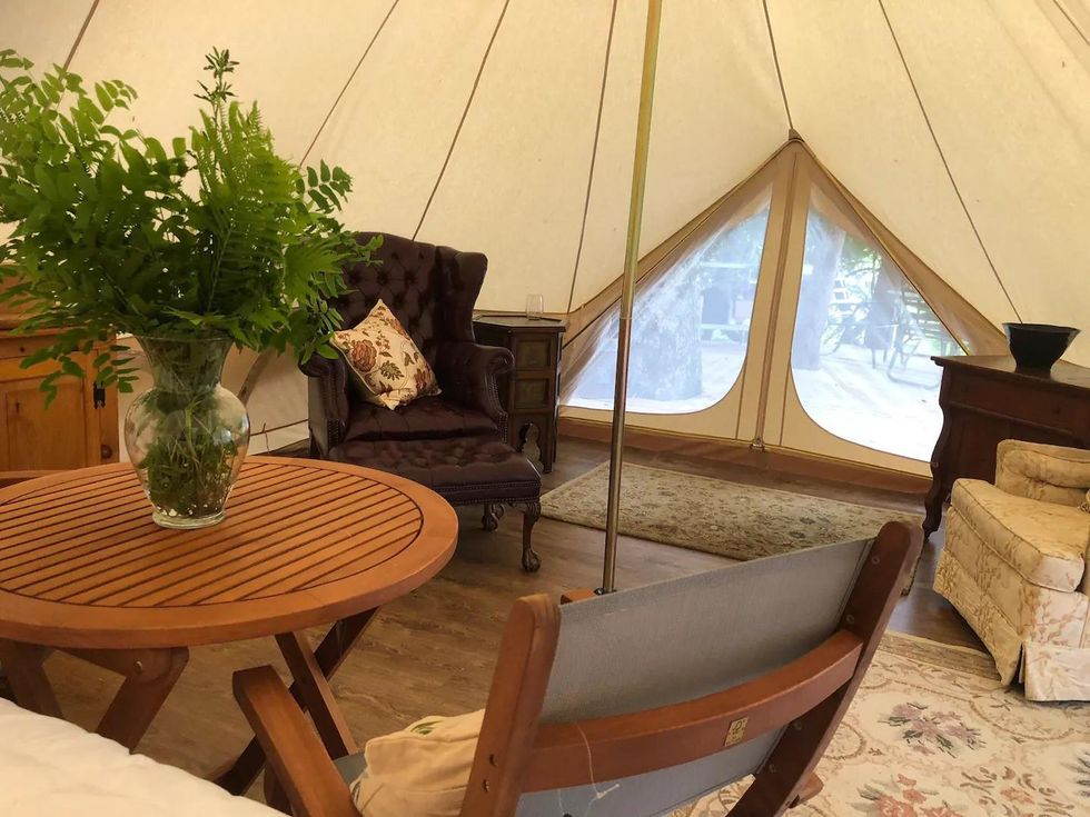 Interior of glamping tent Airbnb in Ontario, with rugs and armchairs.