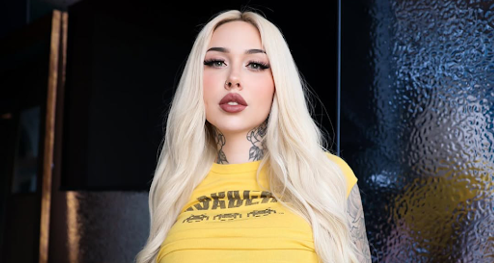 Jade Lavoie  wearing a yellow t-shirt, long white-blond hair and mauve lipstick.