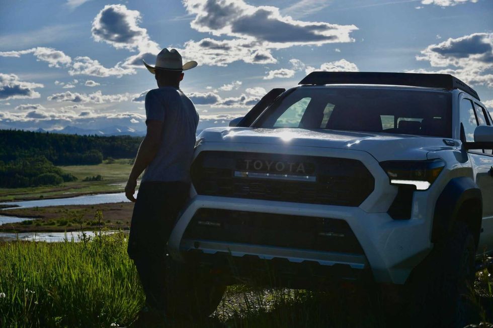 Jake Peacock looks back at the landscape behind him while standing next to his Toyota Tacoma Trailhunter.