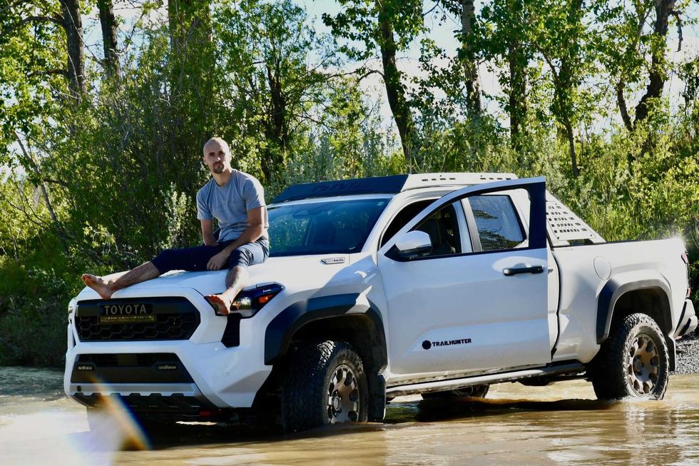 Jake Peacock sits on the hood of his Toyota Tacoma.