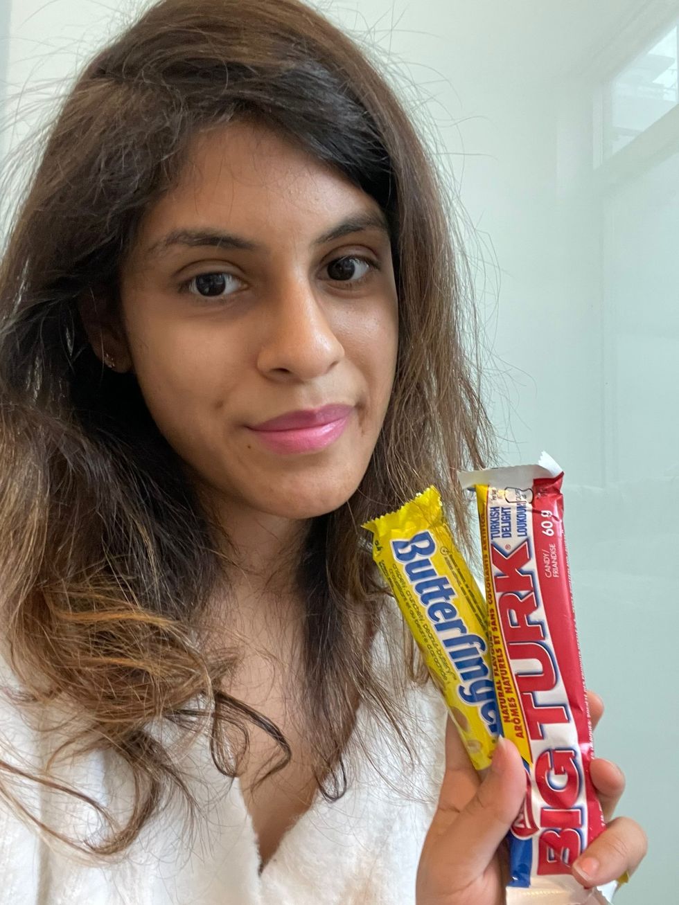 Janice Rodrigues holding Big Turk and Butterfinger candy bars.