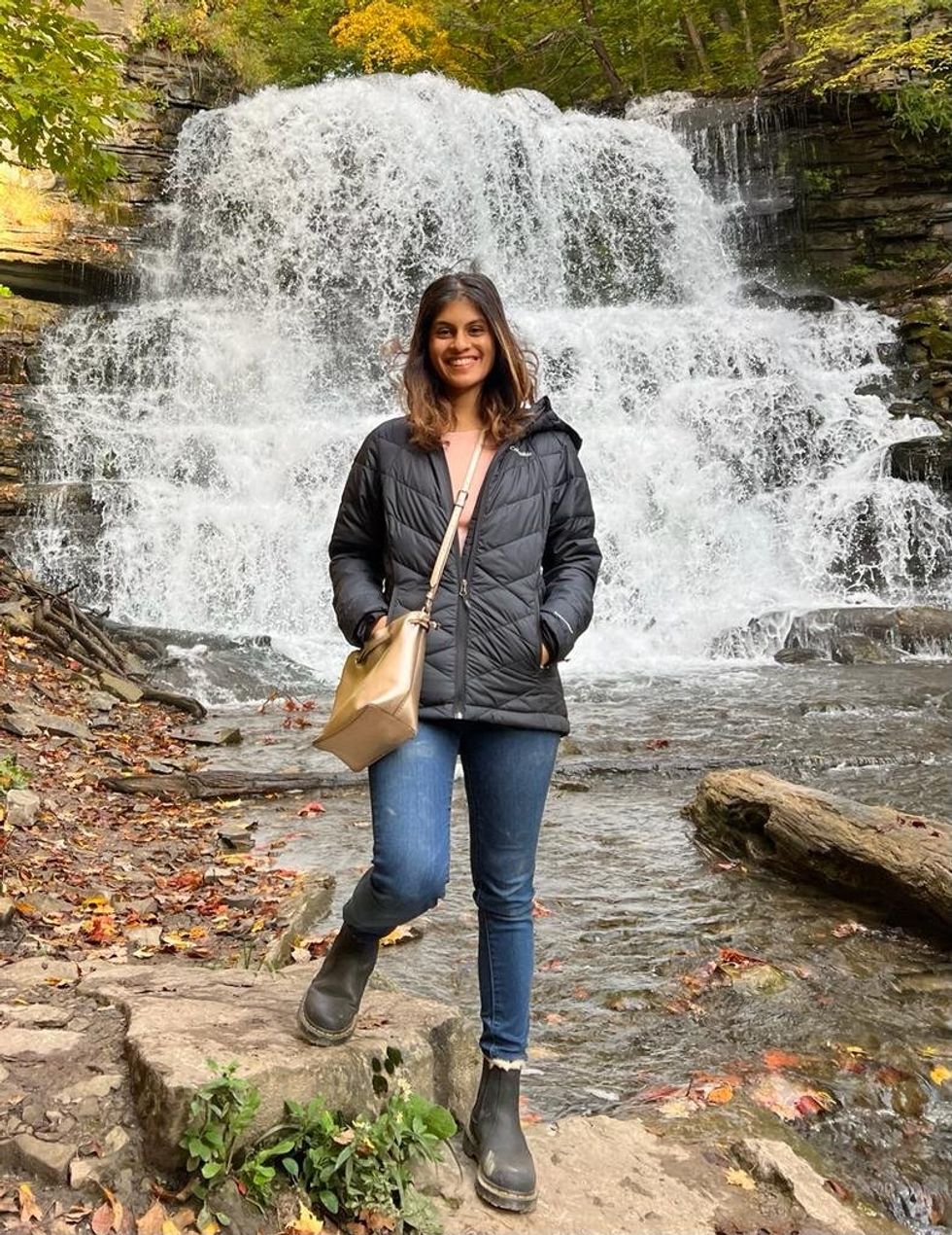Janice Rodrigues poses in front of a waterfalls in Ontario.