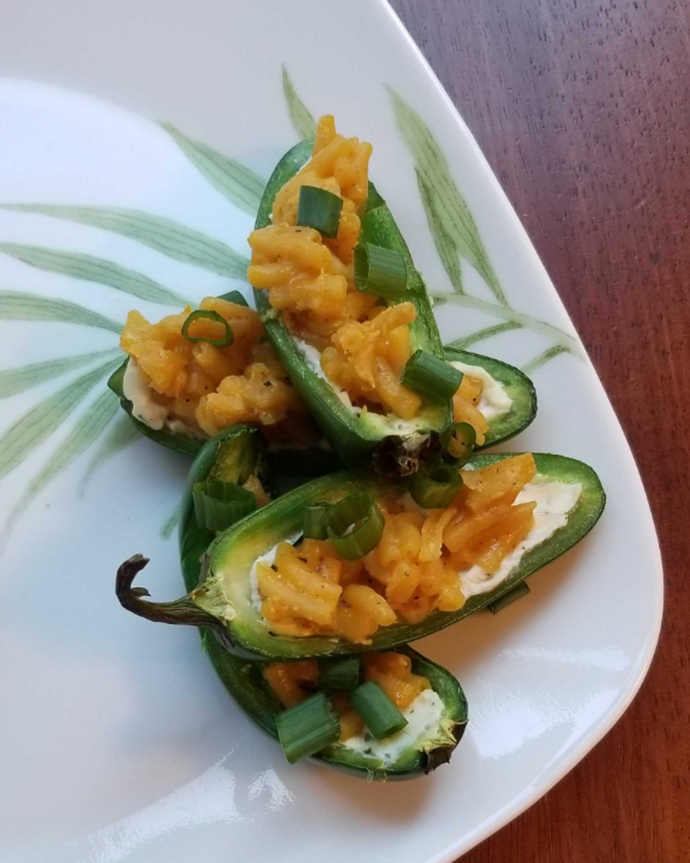 Japapeno halves stuffed with cream cheese, Kraft Dinner and green onion.