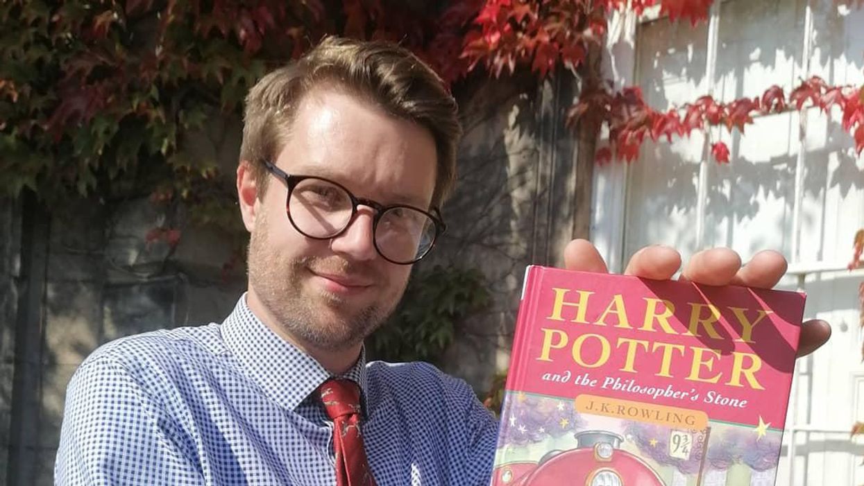 Jim Spencer holds his old copy of Harry Potter and the Philosopher's Stone in his hands.