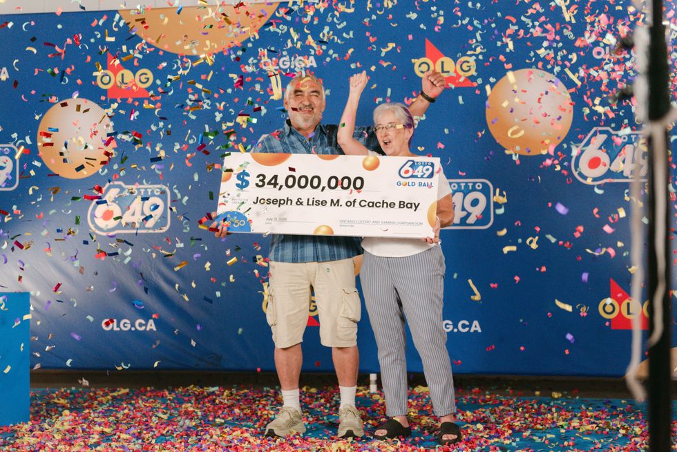 joe and lise menard holding a $34 million lotto 6/49 cheque as confetti falls around them