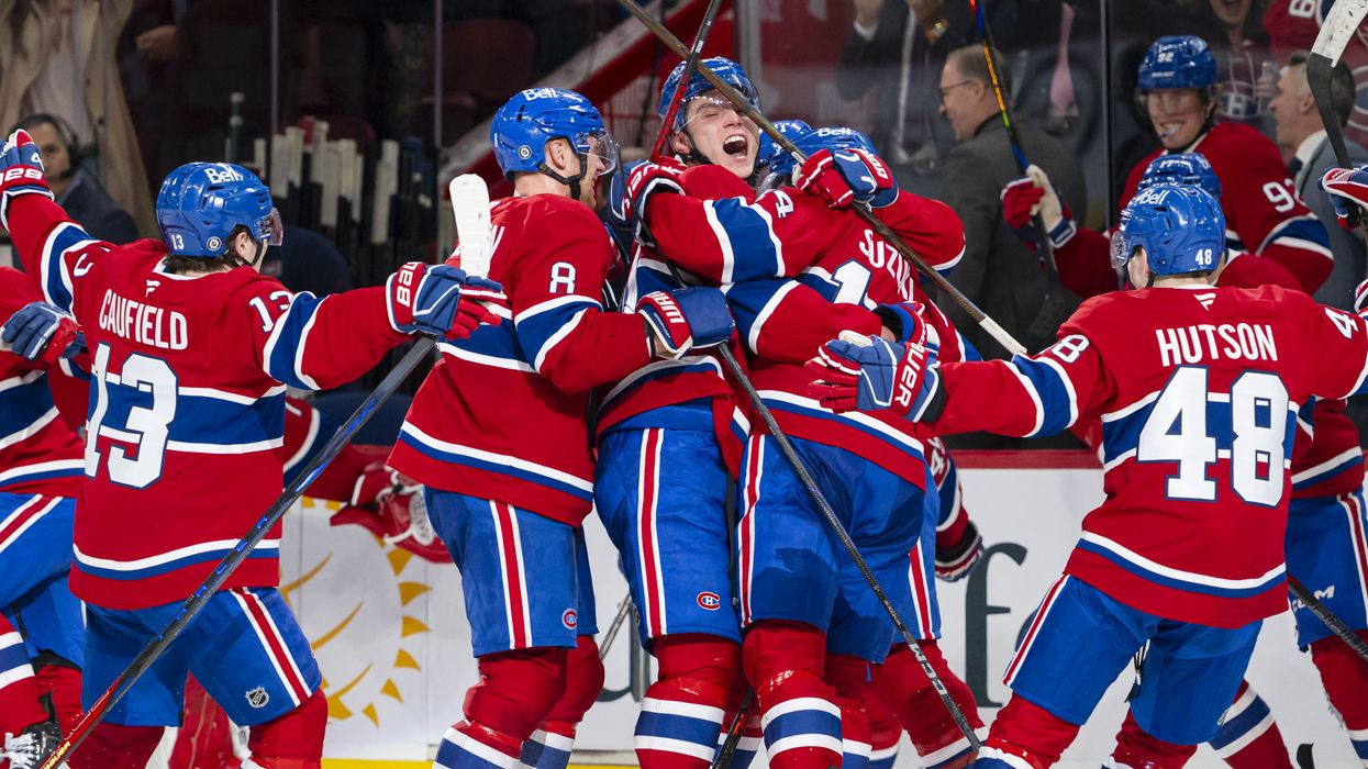 Joueurs du Canadien de Montréal en uniforme rouge célébrant un but sur la glace du Centre Bell.