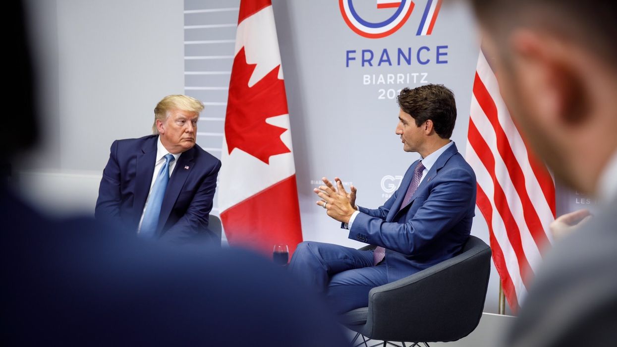 justin trudeau and donald trump at a summit sitting in front of canadian and american flags