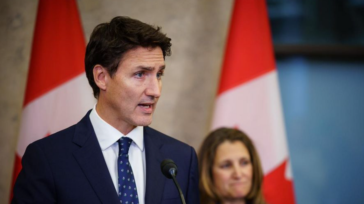 Justin Trudeau makes an announcement with Chrystia Freeland in the background.
