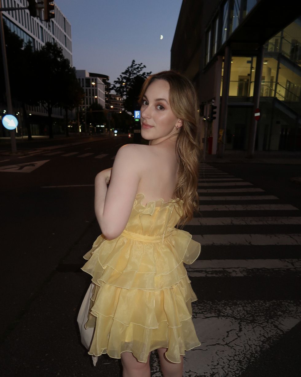 Kassie Montgomery poses in her yellow Eras Tour dress.