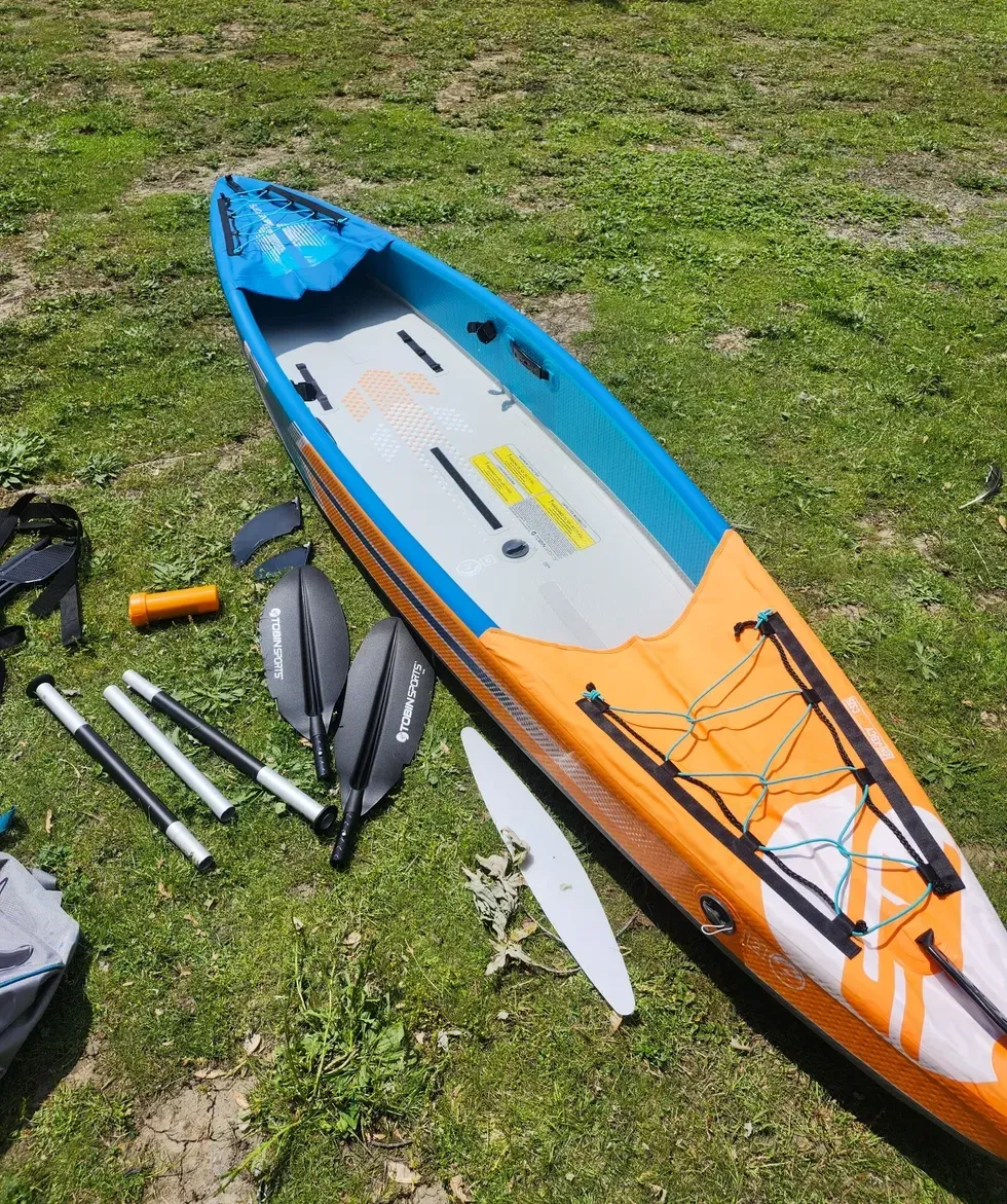 Kayak gonfl\u00e9 avec \u00e9quipement au sol.