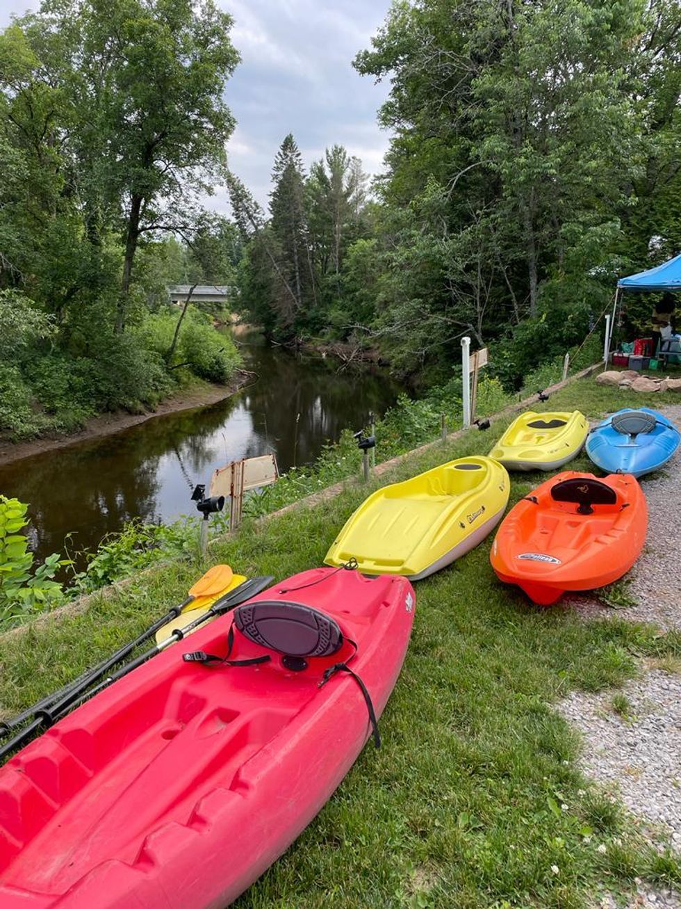 Kayaks next to a river.