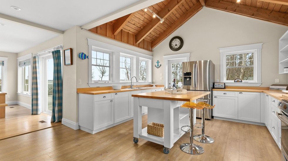 Kitchen in the house for sale which has vaulted ceilings.