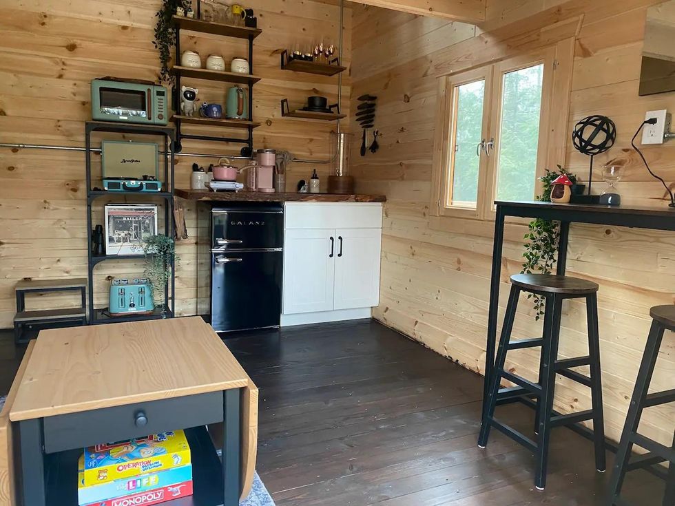 Kitchenette, bar and coffee table in a treehouse cabin.