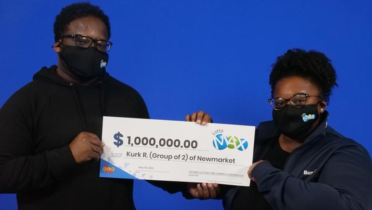 Kurk Roberts and Chanel Goodwin holding a giant cheque.