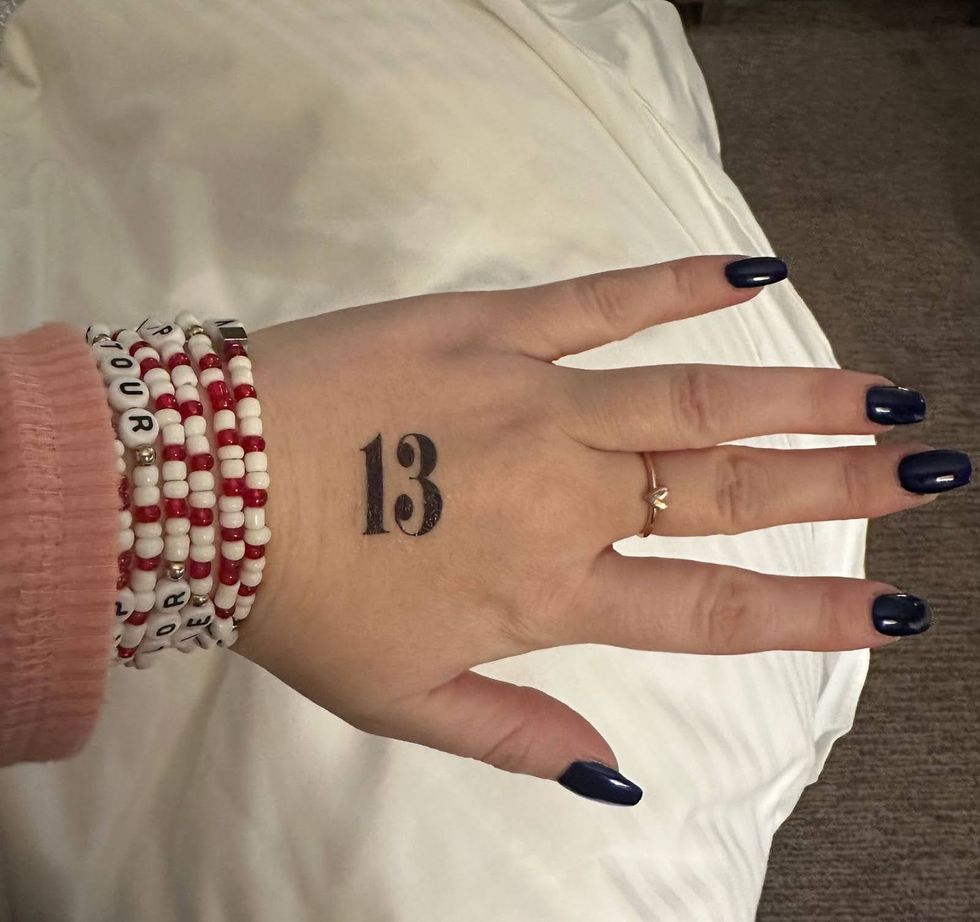 La belle-fille de Keith Murray, Meaghan, pr\u00e9sente ses bracelets d\u2019amiti\u00e9 et son tatouage \u00ab 13 \u00bb sur la main en pr\u00e9paration du spectacle.