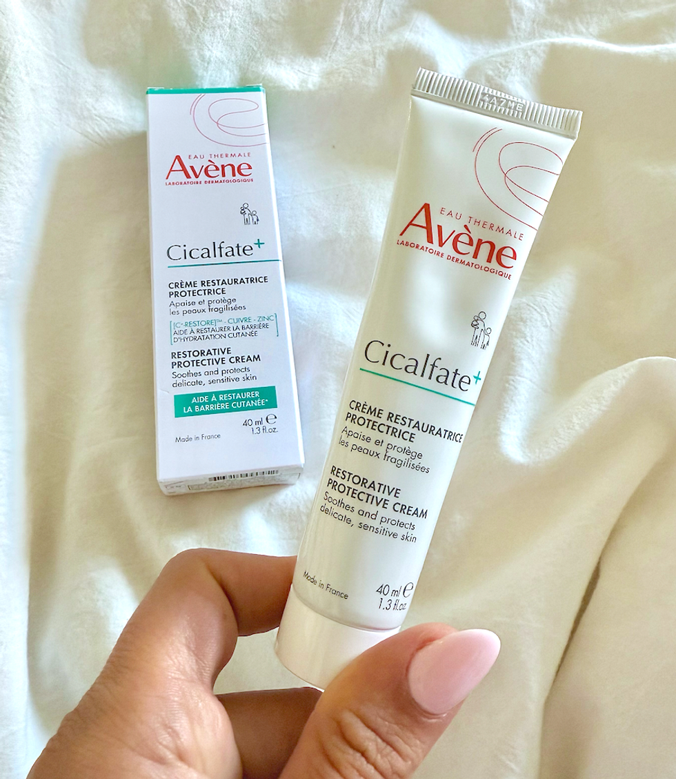 la cr\u00e8me Cicalfate+ d\u2019Av\u00e8ne dans une main.