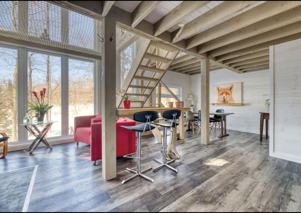 La cuisine moderne avec de grandes fen\u00eatres et un divan rouge de l'\u00c9co Chalet La Renarde.