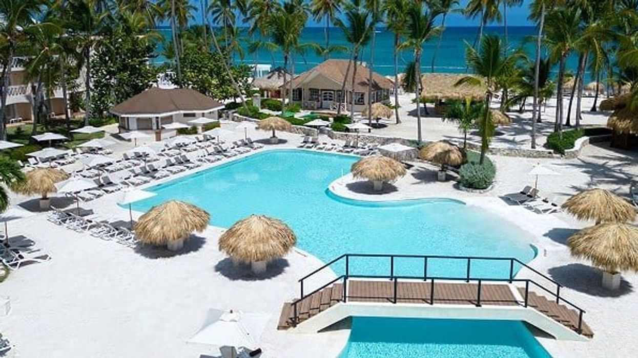 La piscine entourée de palmiers, de chaises longues et de palapas du resort Sunscape Coco Punta Cana.