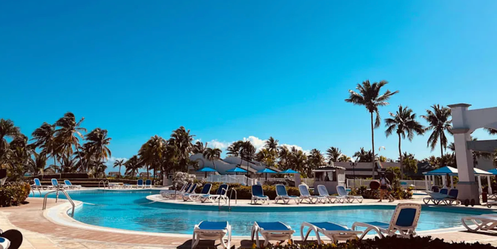 La piscine, les chaises longues et les palmiers de l'h\u00f4tel Hotel Vigia \u00e0 Cuba.
